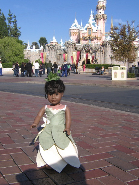 May in her Tiana dress in front of Sleeping Beauty's Castle (decorated for Christmas)