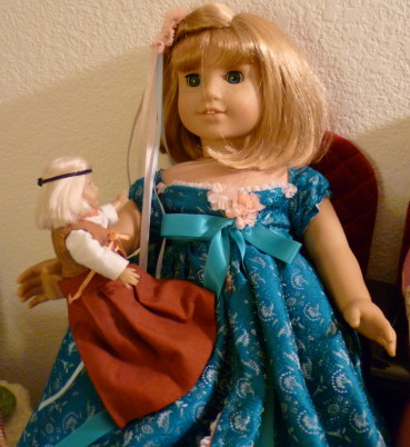 Mini Kit in her brown Ren-Faire-style outfit sits on Nellie's lap.  Nellie is wearing Giselle's turquoise "curtain" dress from "Enchanted."
