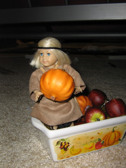 Mini Kit sits on the bin, holding a pumpkin.