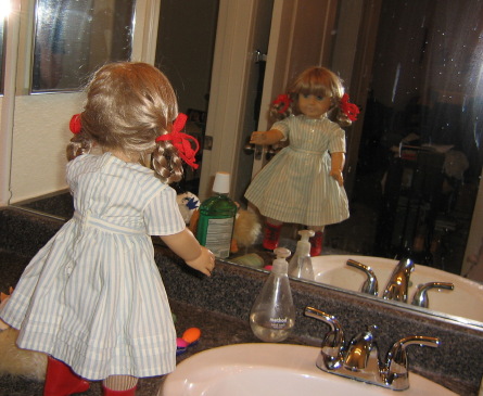 Kirsten sees Evil Kirsten in the mirror.